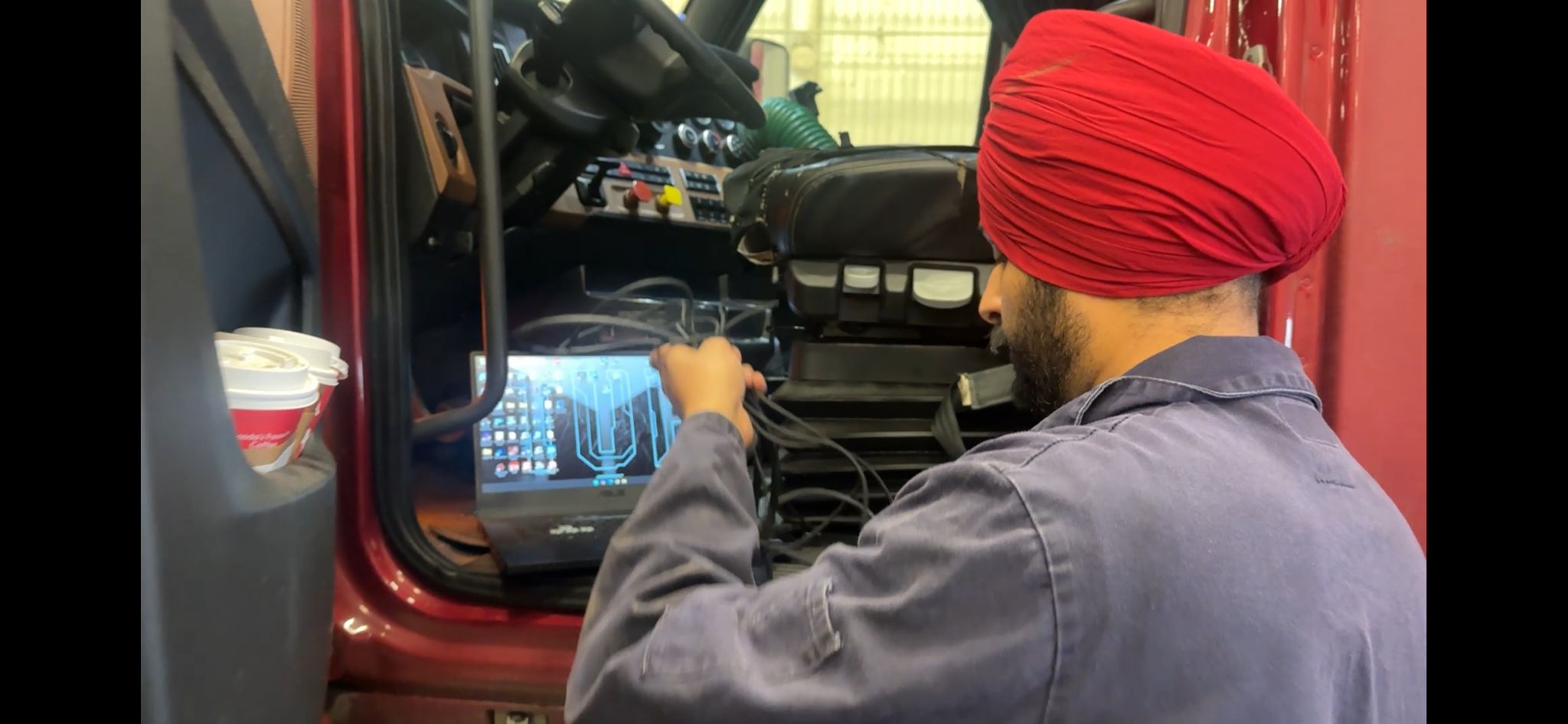 Mechanic performing advanced engine diagnostics on a fleet truck