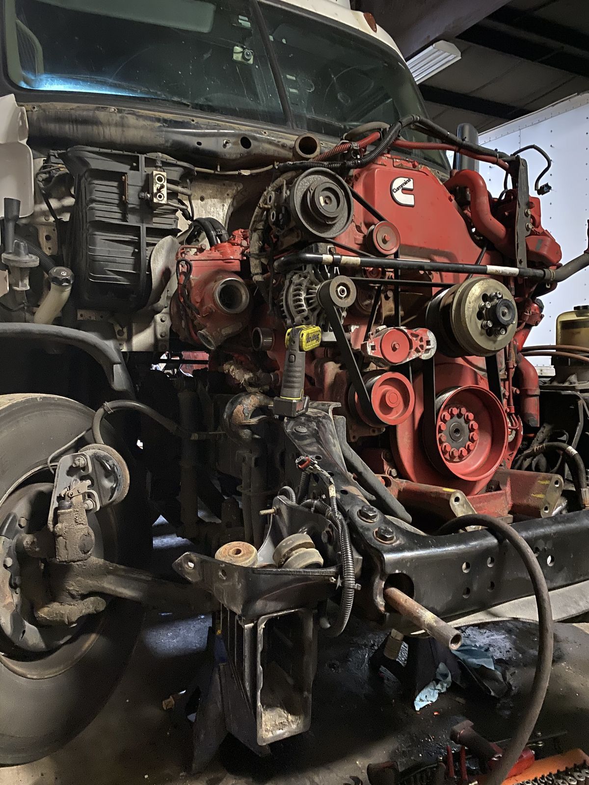 Mobile service technician repairing a diesel truck engine on location